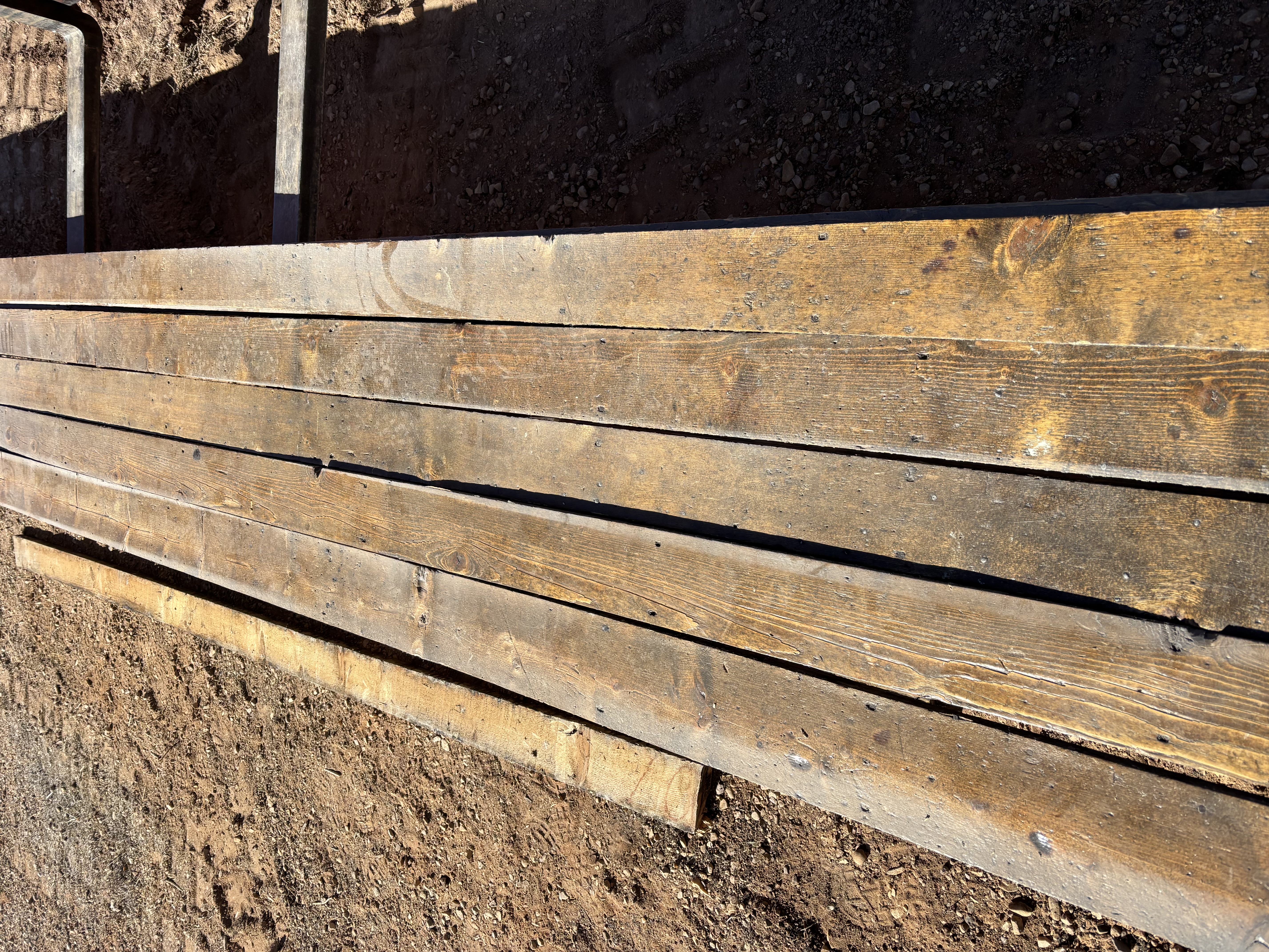Stack of about fifty 6-foot pioneer flooring boards, showing the true 1-inch thickness under a light layer of dust